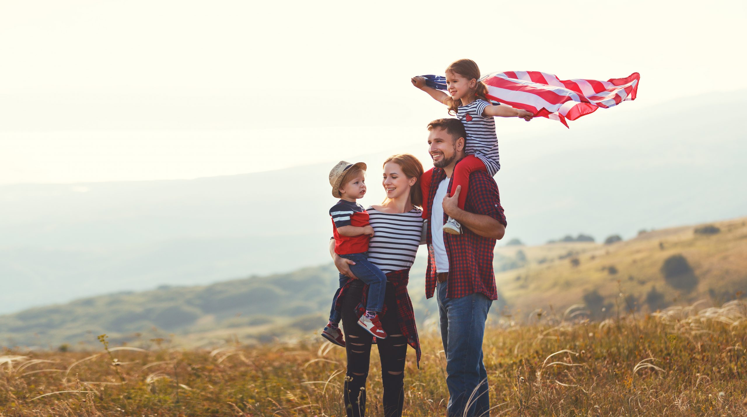 A family stands outside with an American flag