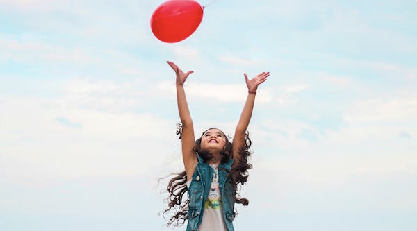 girl tossing balloon in air
